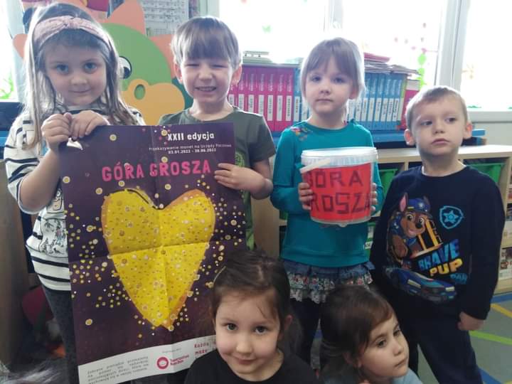 Dzieci z plakatem informacyjnym akcji Góra Grosza i z puszką na datki