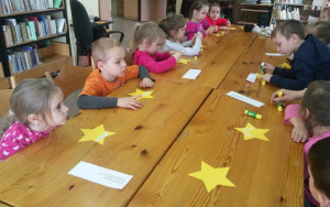 Dzieci wyklejają swoje imiona z papierowych kartoników na żółtych gwiazdkach