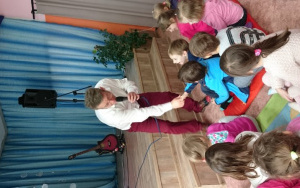 Pan Adam z mikrofonem podaje dzieciom rękę