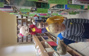 przedszkolaki przeglądają książki na półkach w towarzystwie Mysi