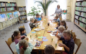dzieci wykonują prace plastyczne przy stolikach