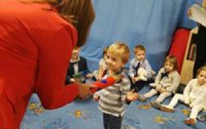 Pani Dyrektor pasuje na przedszkolaka chłopca w bluzie w paski