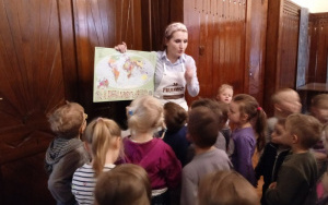 pani pokazuje dzieciom na mapie świata dokąd wyruszająw podróż