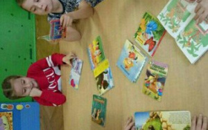 szóstka dzieci przy stoliku ogląda książeczki