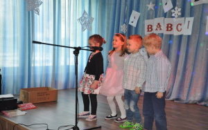 dwie dziewczynki i wóch chłopców śpiewa przy mikrofonie