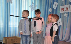 czterech przedszkolaków oczekuje na występ przy mikrofonie