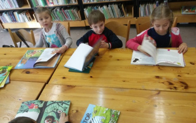 Roksana, Kazio i Maja przeglądają książki