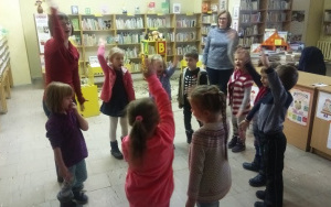Dzieci w kole śpiewają piosenkę ilustrując ją ruchem
