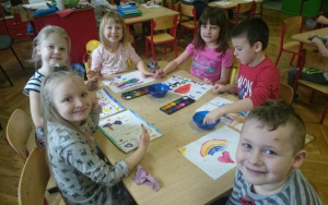 dzieci przy stoliku malują farbami za pomocą palców