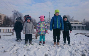 dzieci stoją na sniegu gotowe do zabawy