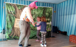 Tata - świnka tańczy na scenie z dwiema dziewczynkami