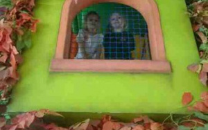 dziewczynki za siatką w zielonym domu na wysokości