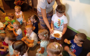 Patryk z pomocą cioci Violi częstuje dzieci ciasteczkami