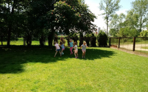 Grupa dzieci gra w piłkę nożną na trawie
