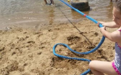 dzieci przeciągają linę z wody na plażę