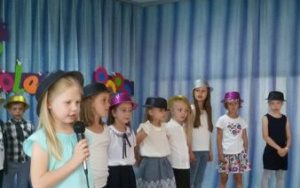 Grupka dzieci na scenie prezentuje przygotowany repertuar