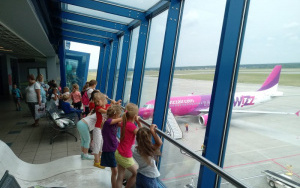 Dzieci na tarasie widokowym obserwująobsługę techniczną samolotu