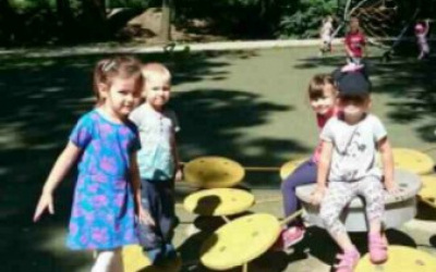dzieci na placu zabaw skaczą po żółtych kołach