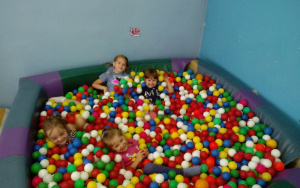 cztery uśmiechniete dziewczynki w basenie z piłkami