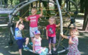 grupka dzieci na pajęczynie ze sznurka na placu zabaw