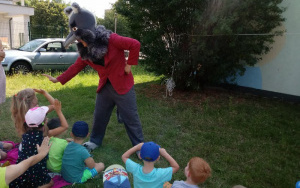 Aktor w przebraniu wilka przybija piątkę z przedszkolakami