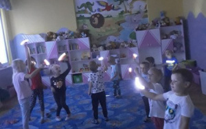 Dzieci z latarkami tańczą taniec gwiazd