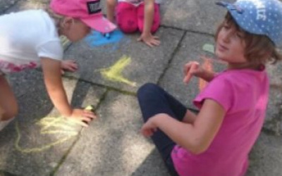 dziewczynki rysują kredą na chodniku