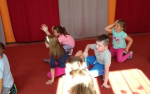 przedszkolaki ćwiczą obrót na kolanie z rączką do góry