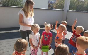 dzieci obok Pani Martynki, na tarasie która tłumaczy dzieciom na czym będzie polegała zabawa