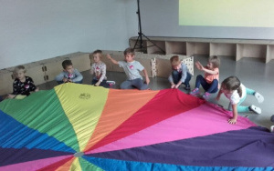 dzieci dookoła kolorowej chusty animacyjnej