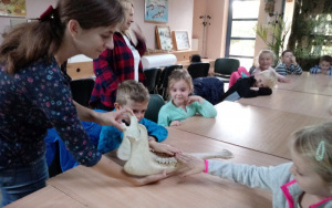 dzieci dotykają zębów żyrafy w jej  czaszce