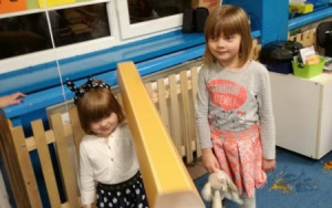 Dwie dziewczynkistojązogromnympapierowymołówkiem,mniejsza trzyma go na ramieniu