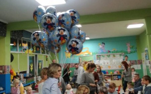 rodzice i dzieci wokół stołu z poczęstunkiem,pani Ania z dużą ilością balonów w ręce