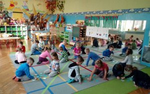 dzieci siedzą na dywanie dobrane dwójkami,grająw misiowe memory