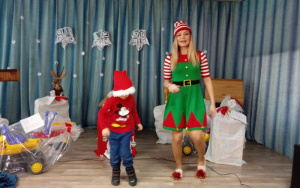 Pani Martynka - elf, wspólnie z chłopcem tańczą na scenie, wśród worków z prezentami