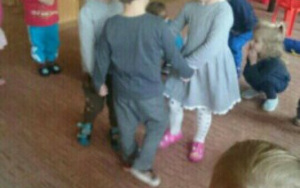 dzieci tańczą w kółeczku na dywanie, na główkach opaski z głową bałwanka