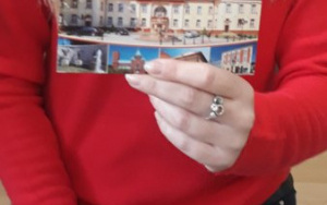 Pani Martynka w czerwonym sweterku pokazuje dzieciom pocztówkę z Czeladzi