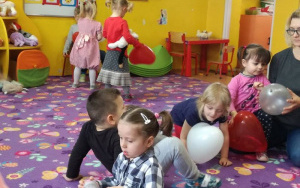 dzieci swobodnie bawią się nadmuchanymi balonami na dywanie