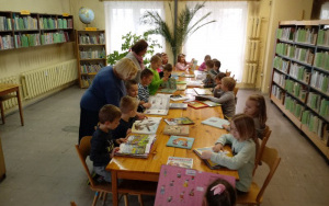 Dzieci przy stolikach, wspólnie z Paniami Marysia i Małgosią oglądają kolorowe książki