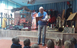 mężczyzna prezentuje dzieciom instrument muzyczny - fletnię