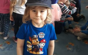 dziewczynka pozuje do zdjęcia w czapce policjanta