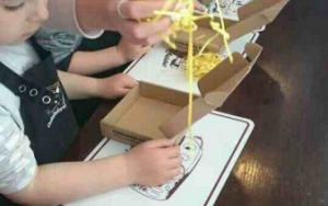 dzieci pakująozdobne wiórki do kartonowych pudełek na czekoladki