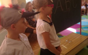 dziewczynki przed tablicą,na tablicy napis kredą - ABC
