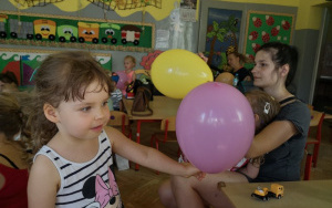 uśmiechnięta dziewczynka trzyma w rączce nadmuchany balon