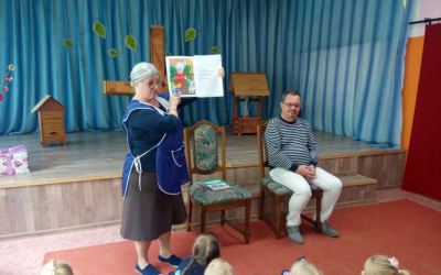 autorka książki prezentuje dzieciom ilustrację do legendy, obok na krześle autor ilustracji
