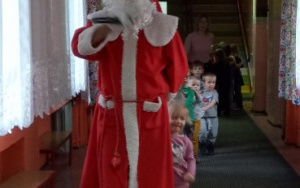 Mikołaj idzie rytmicznie krytarzem, za nim podąża pociąg, który tworzą dzieci