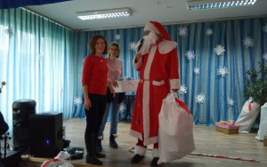 Mikołaj wręcza worek z prezentami dla grupy 4, latków Pani Reni w czerwonej bluzce