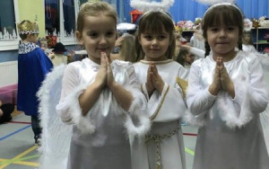 trzy dziewczynki w strojach aniołków - białe sukienki, srebrne aureolki