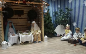 W szopce na scenie Maryja i Józef wraz z dzieciatiem, po prawej stronie trzej królowie w złotych koronach