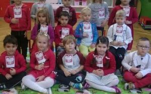 grupa dzieci z godłami Polski w dłoniach pozuje do zdjęcia